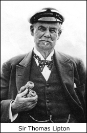A photograph of Sir Thomas Lipton, he is wearing a cap and sports a mustache. He is holding a pair of binoculars.